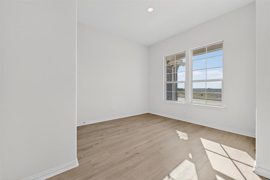 Empty room featuring light wood finished floors and recessed lighting