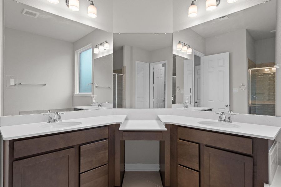 The en-suite bathroom offers a spa-like atmosphere with its elegant design, high end finishes, and tasteful lighting, creating a retreat within your own home.