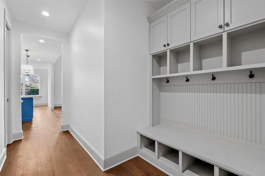 Mudroom featuring dark wood-type flooring and a chandelier