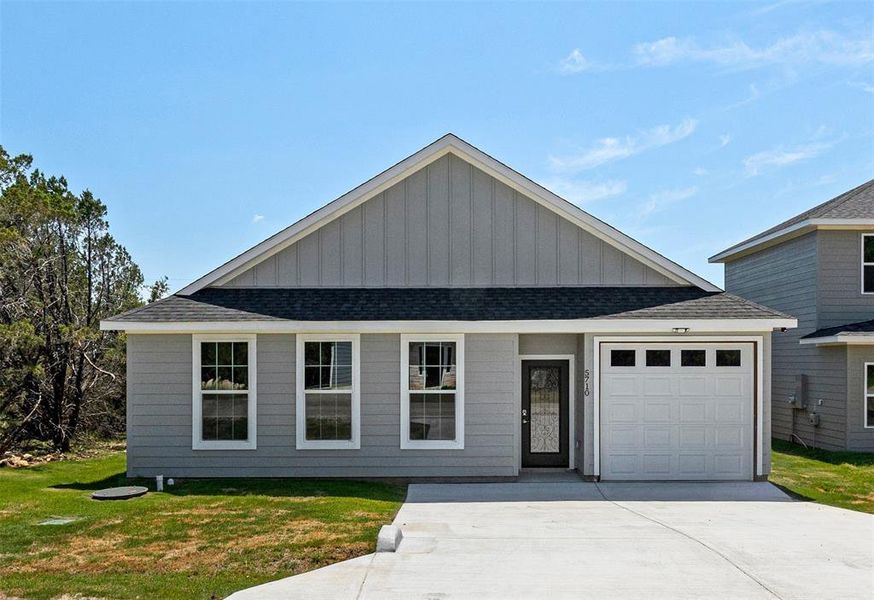 View of front facade with a garage and a front lawn