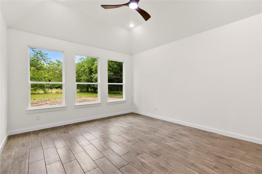 Room featuring wood-finish tile flooring, a vaulted ceiling, and recessed lighting