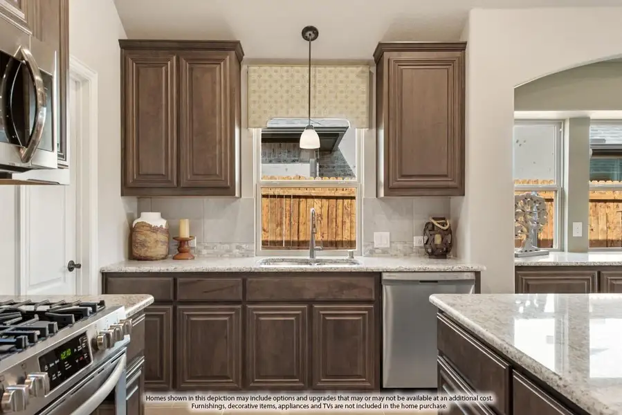 Kitchen with dark brown cabinets, granite countertops, tile backsplash, and stainless steel appliances including gas range and dishwasher.