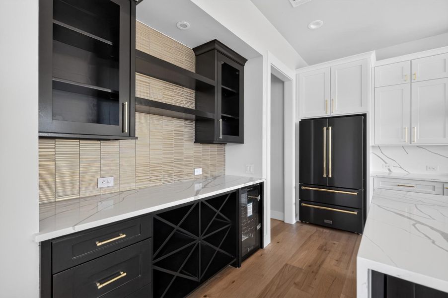 Premium quartz countertops and custom built-ins define this modern kitchen bar area.