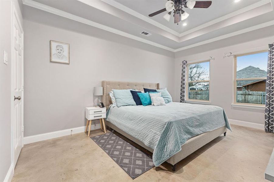 Bedroom featuring a raised ceiling, crown molding, and ceiling fan