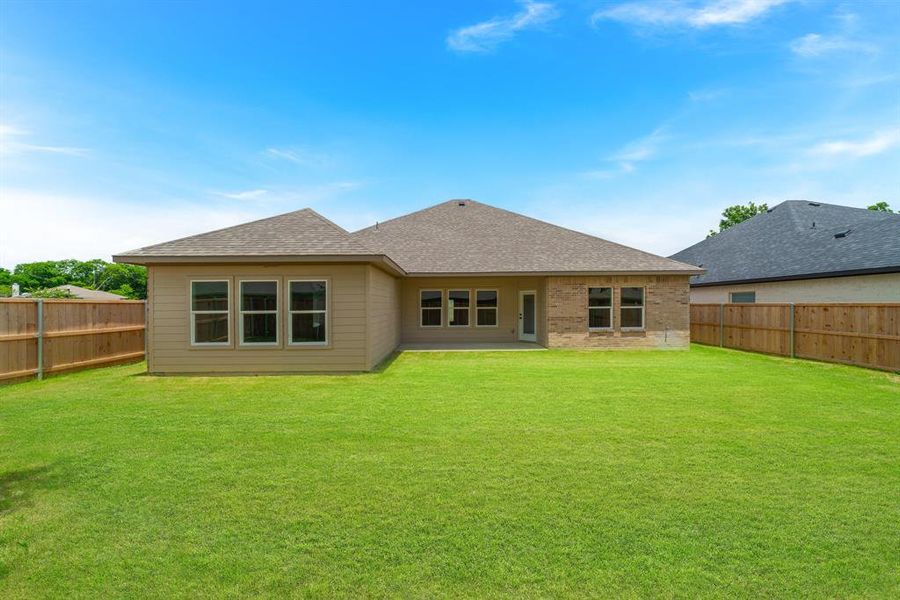 Back of house featuring a lawn