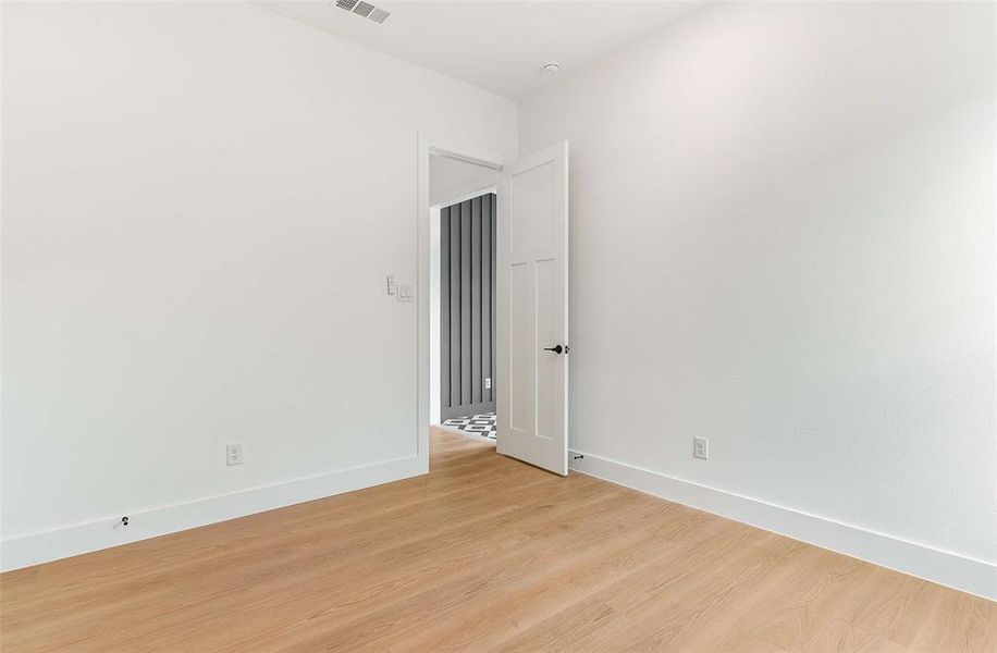 Spare room featuring light wood-style flooring and baseboards