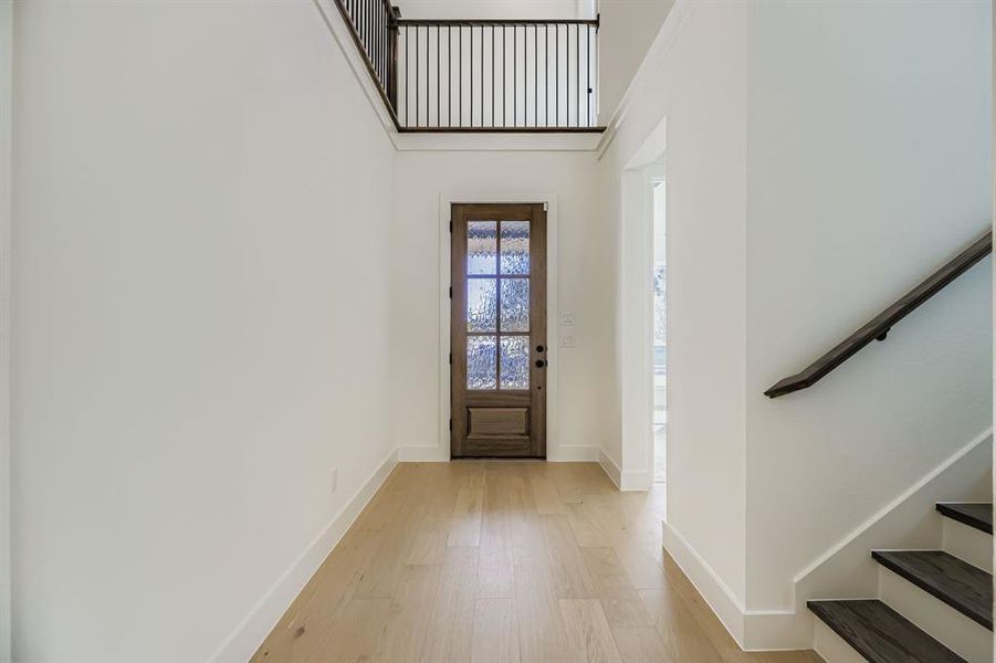 Entrance foyer with stairway and light wood-style flooring