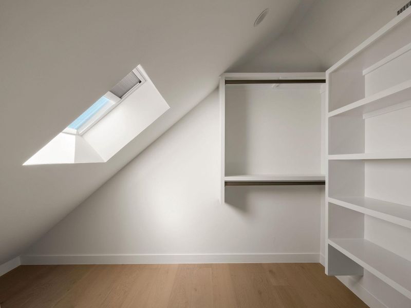 Additional living space featuring vaulted ceiling, light wood finished floors, and a skylight