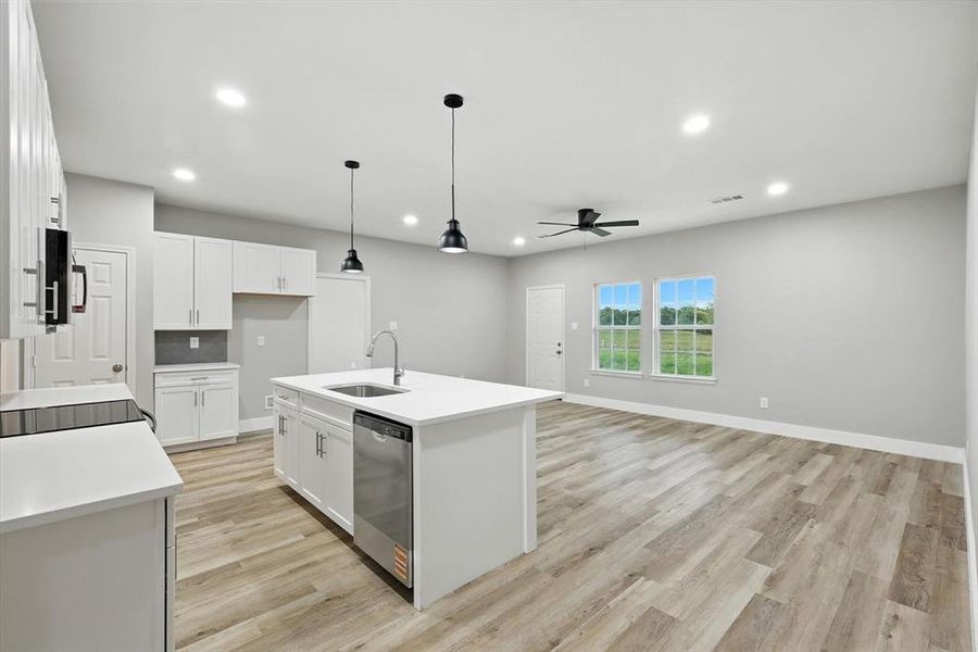 Kitchen with pendant lighting, ceiling fan, white cabinets, recessed lighting, and a center island with sink Kitchen with pendant lighting, ceiling fan, white cabinets, recessed lighting, and a center island with sink