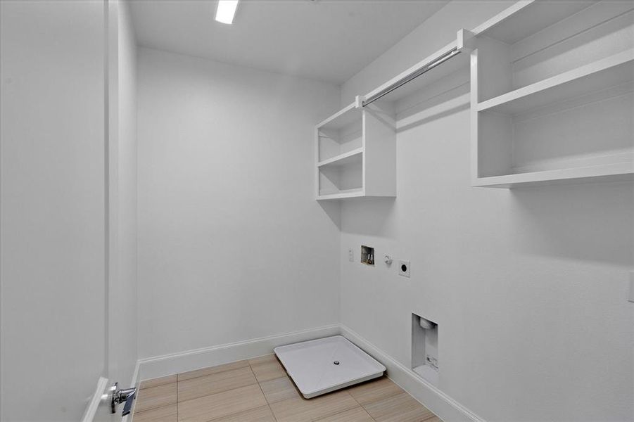 Dedicated laundry room featuring light wood-finish tile flooring and crisp white walls