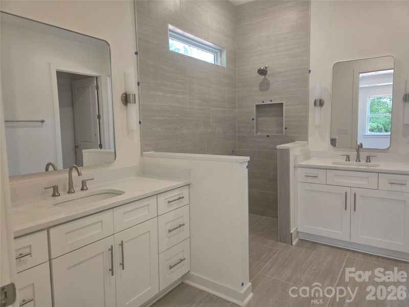 Ensuite primary bathroom with dual vanities and tile to the ceiling shower. Ensuite primary bathroom with dual vanities and tile to the ceiling shower.