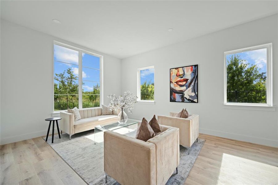 Living room with healthy amount of natural light and light wood-style flooring Living room with healthy amount of natural light and light wood-style flooring