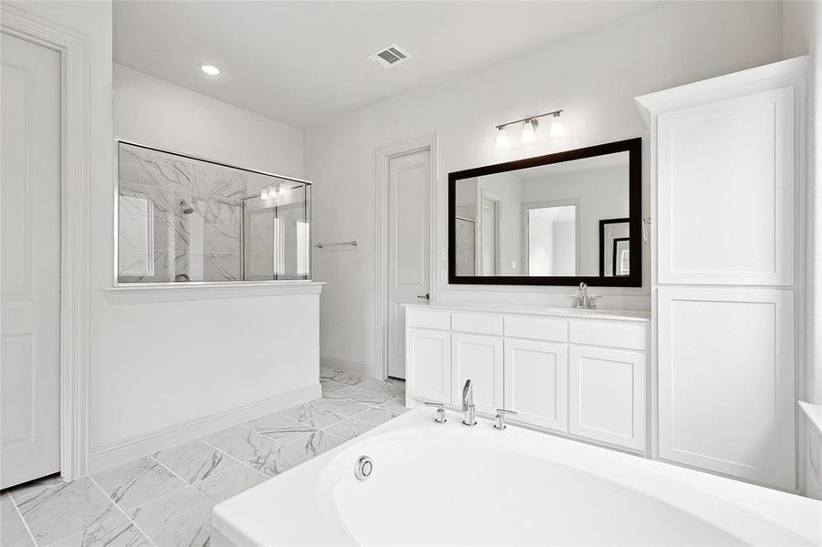 Bathroom featuring vanity, a marble finish shower, light marble finish flooring, and a bath