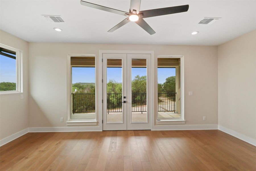 Doorway with baseboards, visible vents, light wood-type flooring, and french doors Doorway with baseboards, visible vents, light wood-type flooring, and french doors