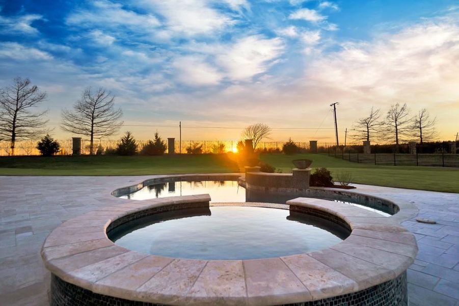 Pool at dusk featuring a patio area and a lawn