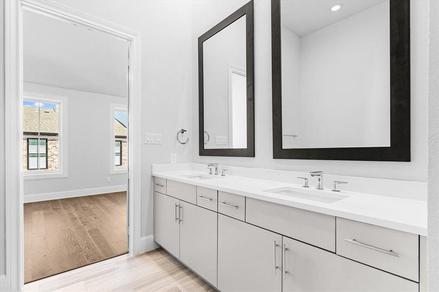 Bathroom with double vanity and light wood finished floors