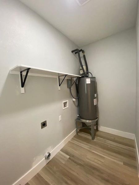 Functional laundry space with a convenient built-in shelf and resilient flooring. Functional laundry space with a convenient built-in shelf and resilient flooring.