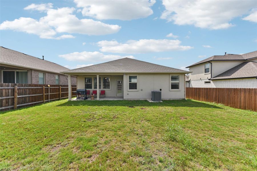 Rear view of house with a patio, a fenced backyard, and roof with shingles Rear view of house with a patio, a fenced backyard, and roof with shingles