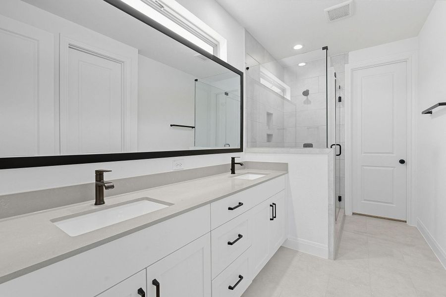 Bathroom with a stall shower, double vanity, recessed lighting, and light tile patterned flooring