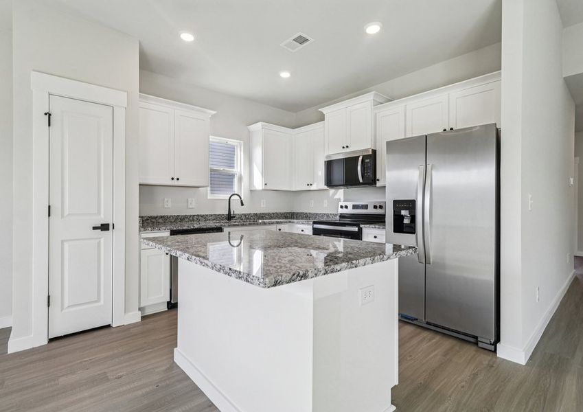 The kitchen has designer wood cabinetry