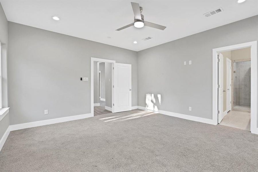 Unfurnished bedroom featuring ensuite bathroom, ceiling fan, and light colored carpet