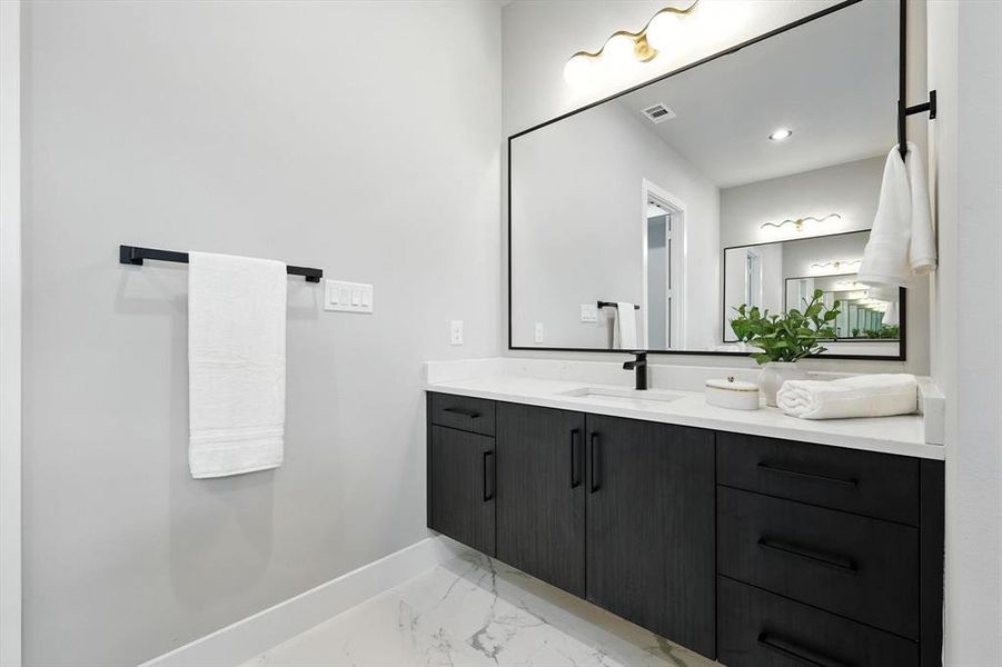 Bathroom with vanity and light marble finish floors