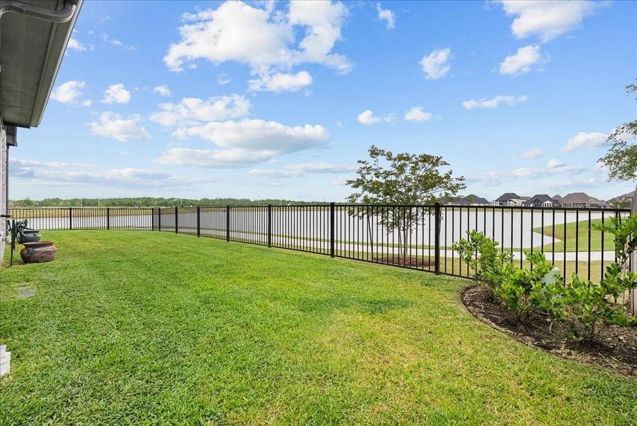 Step outside to enjoy the covered patio and expansive backyard overlooking the water — the perfect place to relax and unwind.