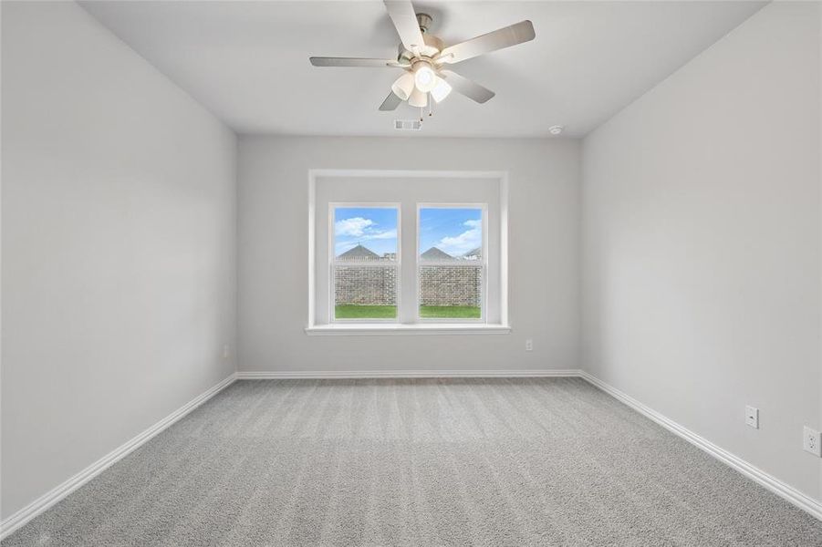 Carpeted spare room featuring baseboards and ceiling fan