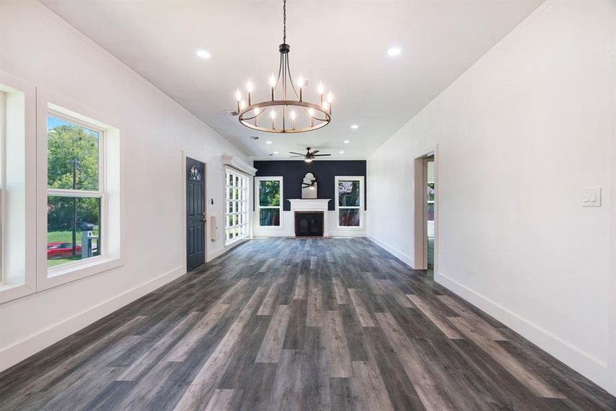living room with a chandelier, dark wood-style floors, a fireplace, recessed lighting, and ornamental molding living room with a chandelier, dark wood-style floors, a fireplace, recessed lighting, and ornamental molding
