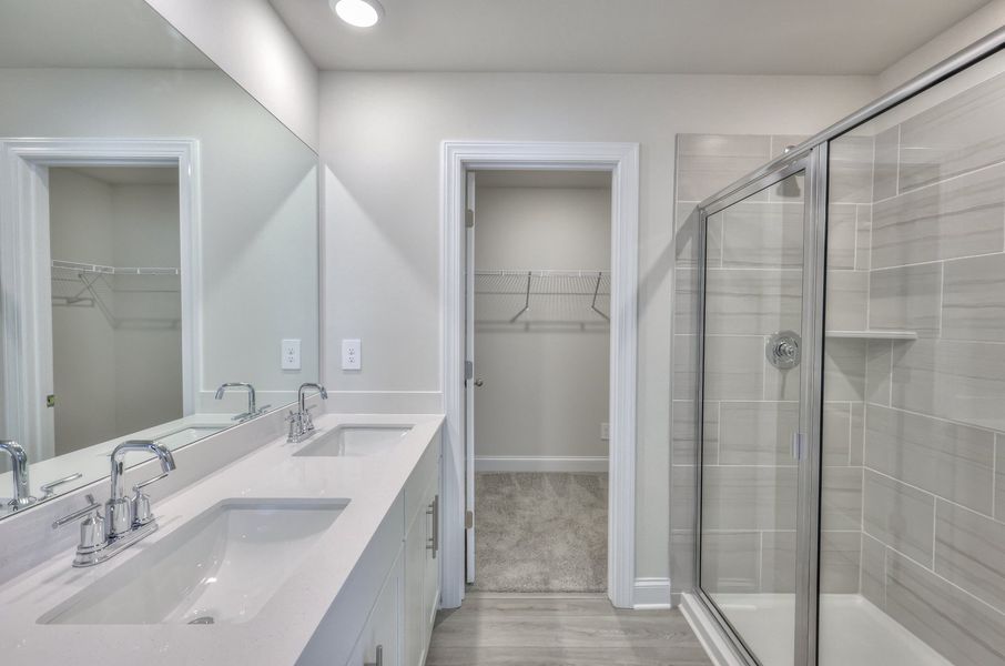 The primary bathroom includes dual vanity sinks and a walk-in shower. The primary bathroom includes dual vanity sinks and a walk-in shower.