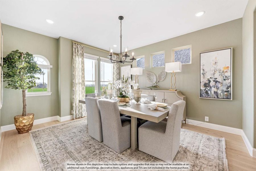 Dining room with gray upholstered chairs, chandelier, hardwood floors, and sage green walls