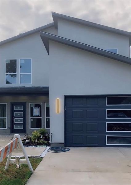 View of front of property with stucco siding, concrete driveway, and a garage View of front of property with stucco siding, concrete driveway, and a garage