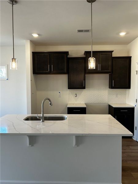 This bright kitchen features sleek countertops, st