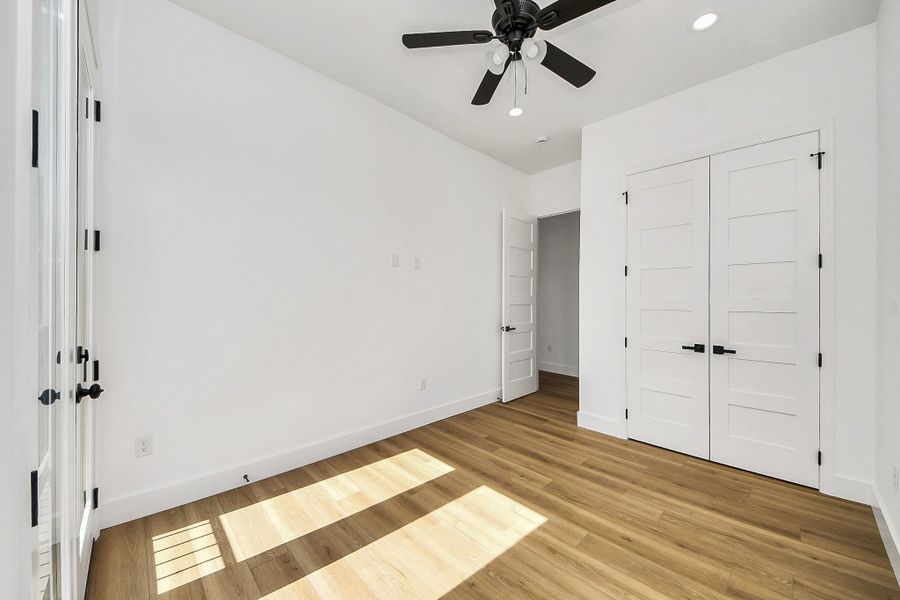Bright and inviting guest bedroom featuring modern finishes, abundant natural light, and a clean, neutral design. A comfortable and versatile space perfect for hosting guests or creating a cozy retreat.