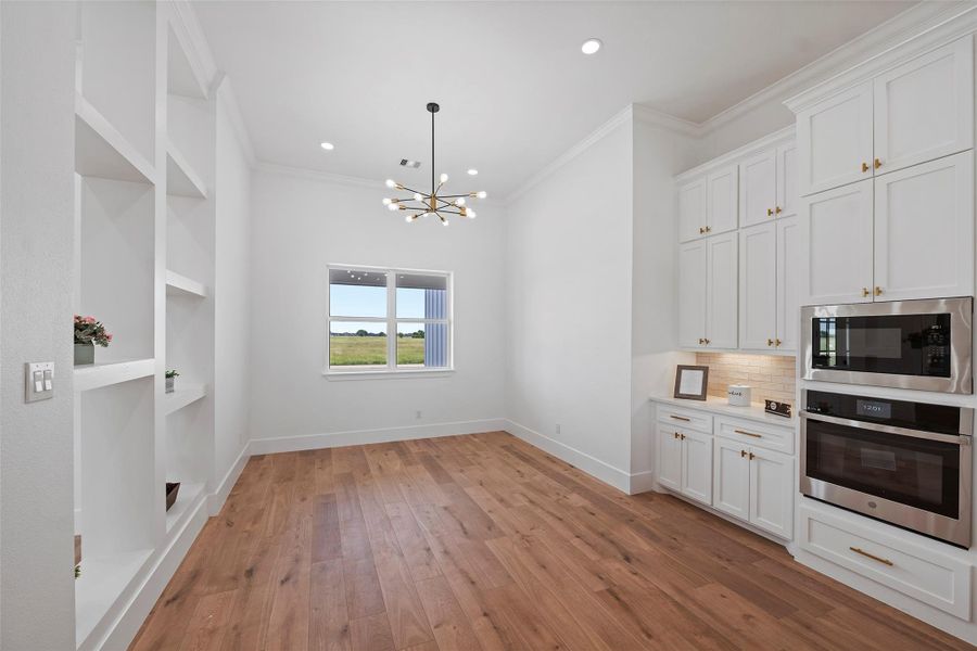 Elegant dining area featuring LVP floors, built-in shelving, and abundant natural light. Perfect for hosting gatherings or intimate meals with a view.