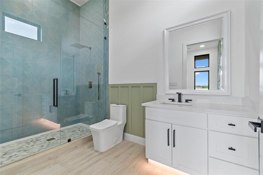 Bathroom featuring walk in shower, toilet, and vanity