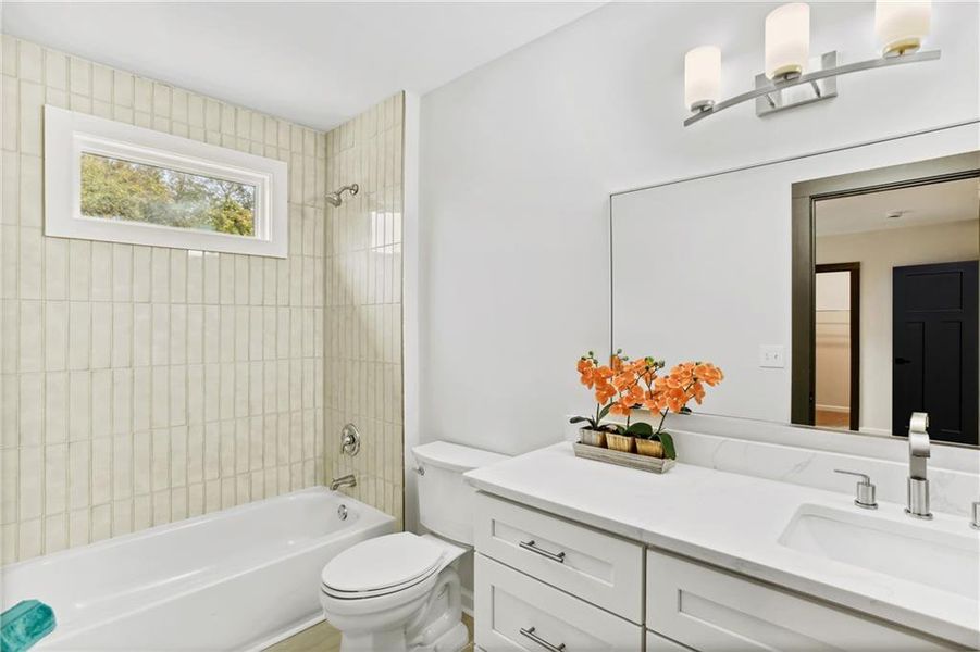 Full bathroom featuring tiled shower / bath combo, toilet, and oversized vanity