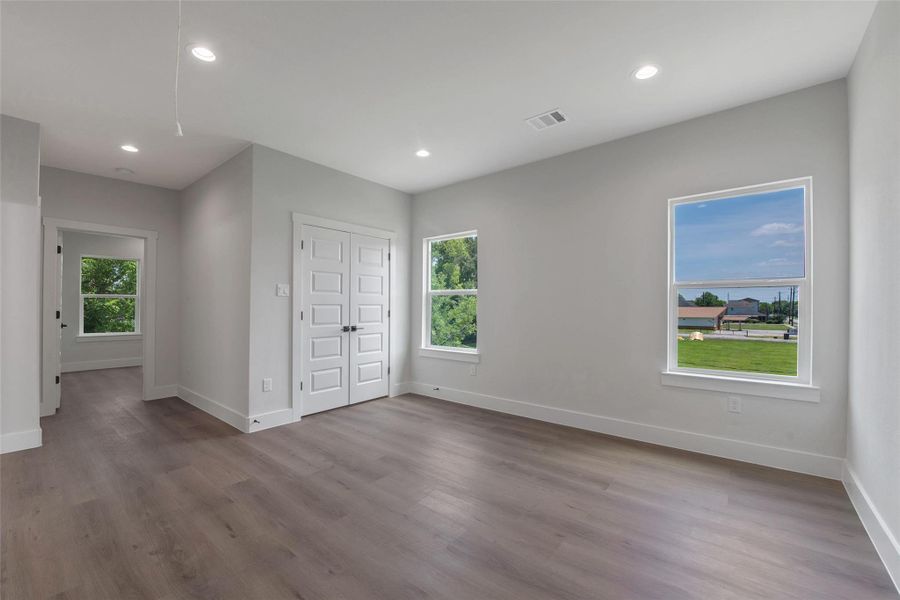A spacious upstairs flex space, filled with natural light from the windows, offers versatile use for work, play, or relaxation, with bedrooms located just off the space for added convenience and privacy, along with a utility closet for practical storage. A spacious upstairs flex space, filled with natural light from the windows, offers versatile use for work, play, or relaxation, with bedrooms located just off the space for added convenience and privacy, along with a utility closet for practical storage.