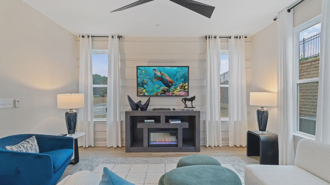 Spacious family room with large windows, ceiling fan and open layout in new construction townhome in Riverdale, GA.