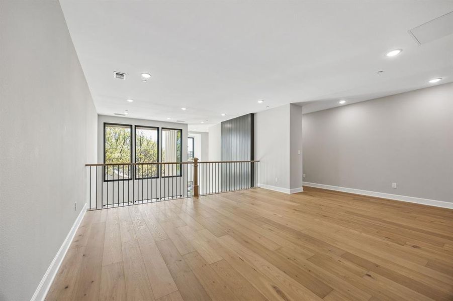 Empty room with light wood finished floors and recessed lighting Empty room with light wood finished floors and recessed lighting