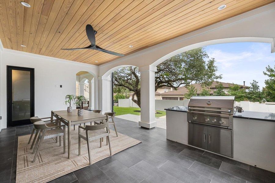 Spacious covered patio featuring a wood-panel ceiling, recessed lighting, and a modern ceiling fan