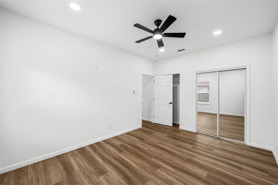 Bright room featuring wood-finish flooring, recessed lighting, and a ceiling fan Bright room featuring wood-finish flooring, recessed lighting, and a ceiling fan
