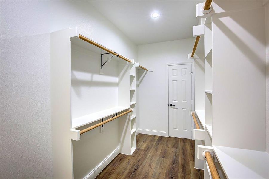 Walk in closet featuring dark wood finished floors Walk in closet featuring dark wood finished floors