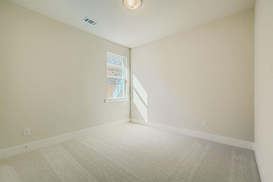 Carpeted spare room featuring baseboards