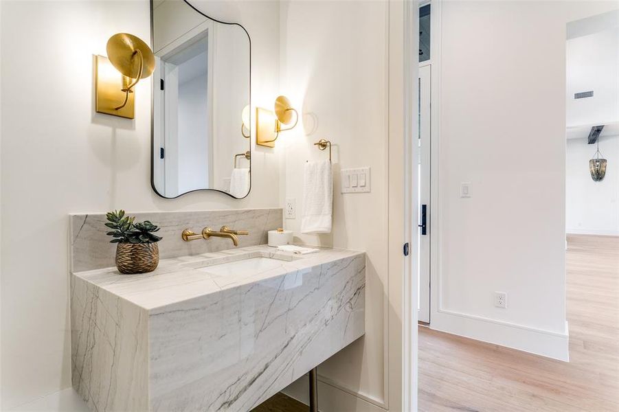 Elegant powder bath with stunning waterfall sink console. Beautiful lighting and custom mirror. Elegant powder bath with stunning waterfall sink console. Beautiful lighting and custom mirror.