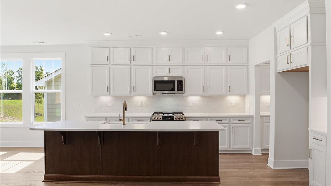 Memorable meals begin in this vibrant kitchen with quartz countertops and a thoughtfully designed island by DRB Homes Memorable meals begin in this vibrant kitchen with quartz countertops and a thoughtfully designed island by DRB Homes