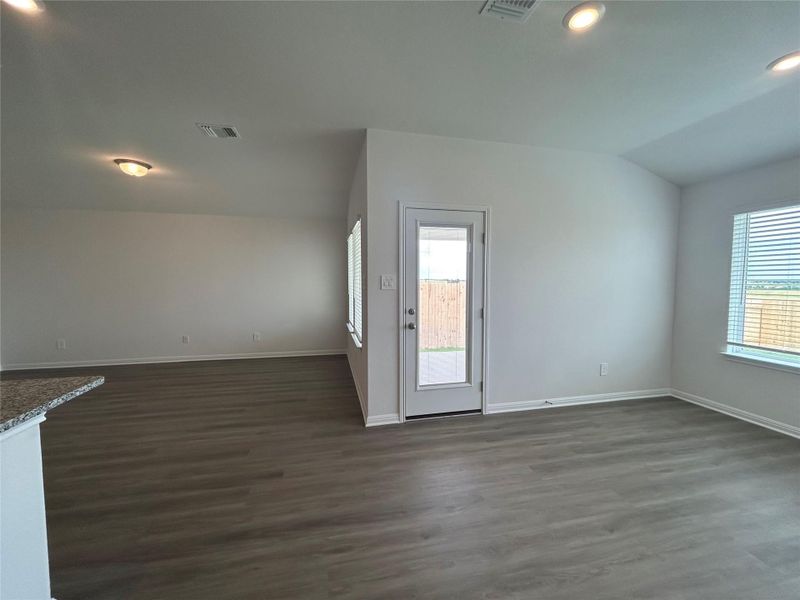 Spare room with healthy amount of natural light, dark wood-style flooring, and recessed lighting Spare room with healthy amount of natural light, dark wood-style flooring, and recessed lighting