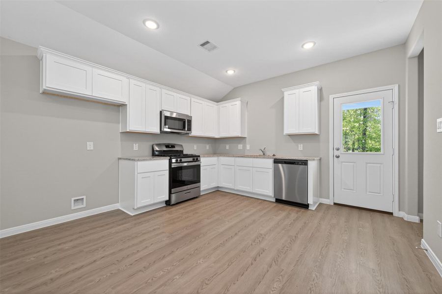Practical L shaped kitchen featuring new appliances, offering an efficient work triangle for ease of use.