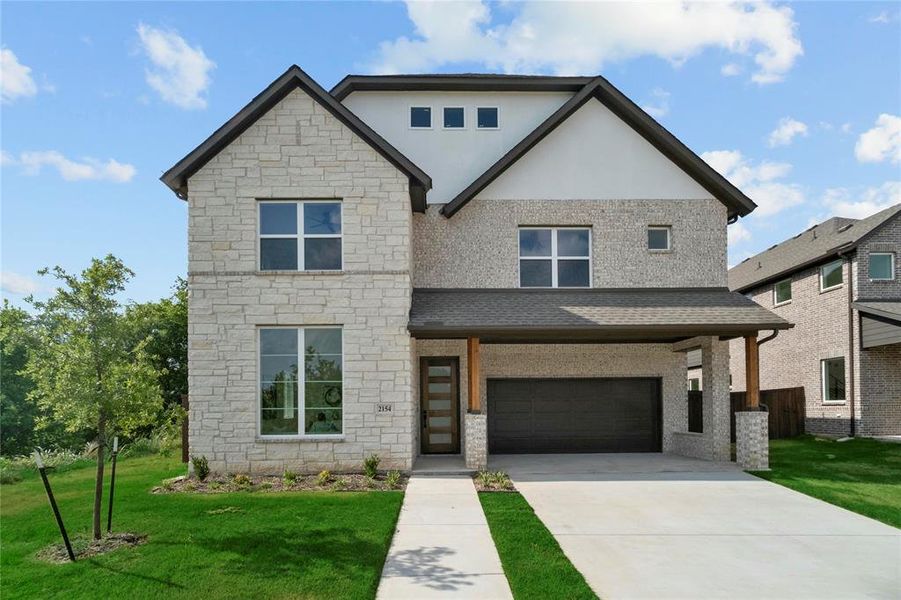 View of front of home with stone siding, a front lawn, an attached garage, driveway, and stucco siding View of front of home with stone siding, a front lawn, an attached garage, driveway, and stucco siding
