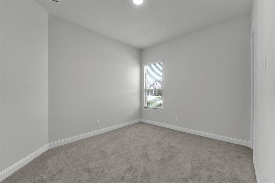 Spare room featuring light carpet and baseboards